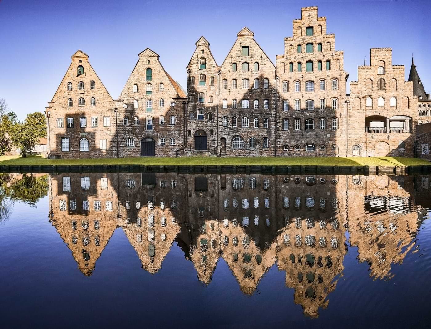 Stepped-gable brick buildings reflected in the water in Lübeck.